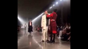 'Young Thug Stops to fix collar of one of his models'